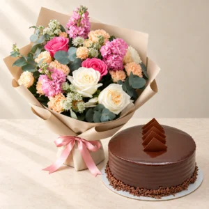Pink and cream Hues of Nature bouquet beside a round chocolate cake